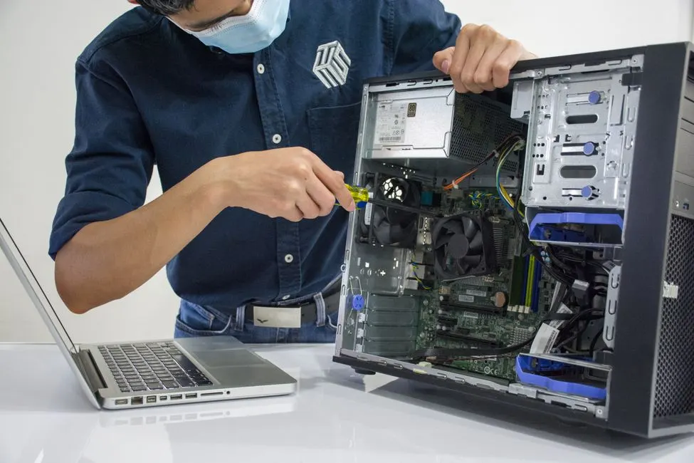 Técnico realizando manutenção de computadores em escritório